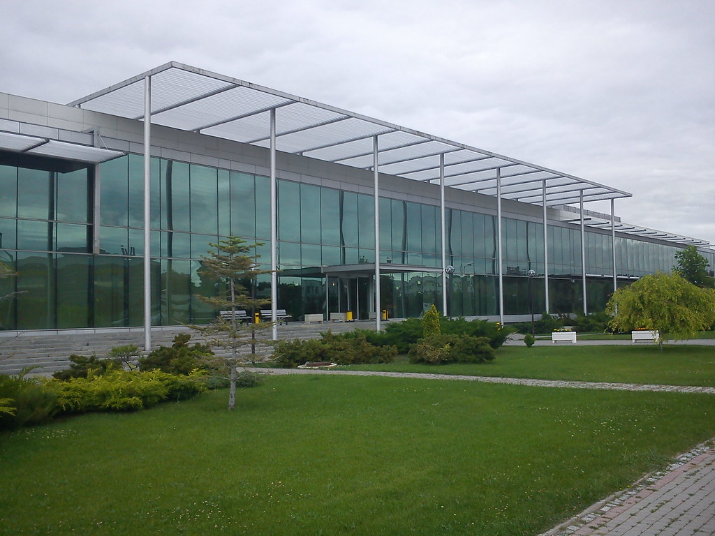 Önünde çimenlik bulunan cam cepheli ofis binası